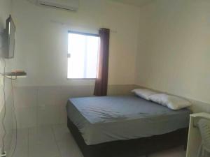 a small bedroom with a bed and a window at Ilheus - Pousada Sol e Mar in Ilhéus