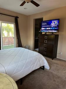 ein Schlafzimmer mit einem Bett und einem Flachbildfernseher in der Unterkunft Oasis in Southern California for 8 guests in Winchester