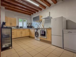 eine Küche mit Holzschränken und einem weißen Kühlschrank in der Unterkunft Maison avec parking à 10min du centre-ville à pied in Chartres