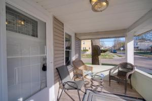 eine Veranda mit 3 Stühlen, einem Tisch und einem Fenster in der Unterkunft Akron Made Easy! Spacious Family Home Near Dtwn in Akron
