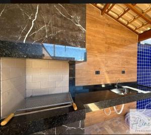a kitchen with a sink and a counter top at Cantinho do Descanso in Peruíbe