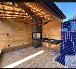a room with a kitchen with wooden walls and blue tiles at Cantinho do Descanso in Peruíbe
