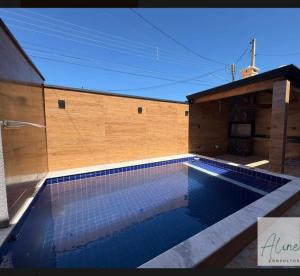 a swimming pool in front of a building at Cantinho do Descanso in Peruíbe