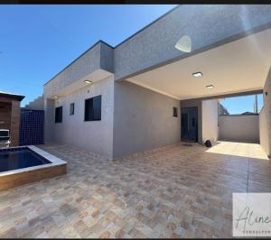 a house with a swimming pool and a patio at Cantinho do Descanso in Peruíbe