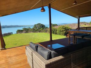 a screened in porch with a couch and a table at Te Papatapu Retreat in Raglan +18 photos