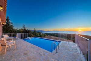 a swimming pool on a balcony with a view of the water at Villa Dioni in Fiskardo