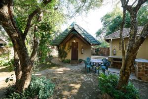 哈博罗内Mokolodi Backpackers的房子前面的一张桌子和几把椅子