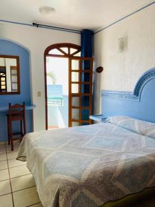 a bedroom with a bed and a view of the ocean at Hotel Jacqueline in Rincon de Guayabitos