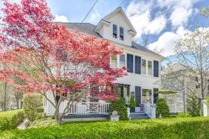 a white house with a flowering tree in front of it at Guestroom in Old Town | Steps to Lake & Everything in Niagara on the Lake