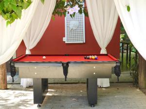 un tavolo da biliardo davanti a un muro rosso di Vila Maria - Linda Casa de Campo a Rio de Janeiro