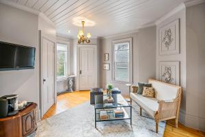 a living room with a couch and a tv at Guestroom in Old Town | Steps to Lake & Everything in Niagara on the Lake