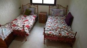 BerrechidにあるLe refuge vertのベッド2台と窓のある寝室