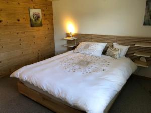 a bedroom with a large white bed with a light on it at Scheftenau in Kappel