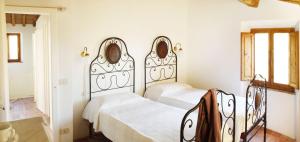 two beds in a room with white walls at Casa Delle Aque in Montecatini Val di Cecina