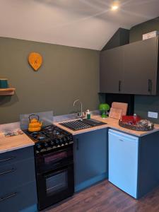 a kitchen with a stove and a counter top at Tranquil Off-Grid Cabin in Ballina +27 photos