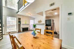 Una cocina y un comedor con mesa y sillas de madera. en Loft-Style Condo in Vickery Midtown 3 Mi to SMU!, en Bouchard
