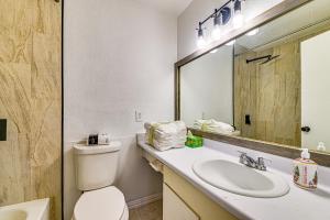 Un baño con inodoro, lavabo y espejo. en Loft-Style Condo in Vickery Midtown 3 Mi to SMU!, en Bouchard 16 fotos más