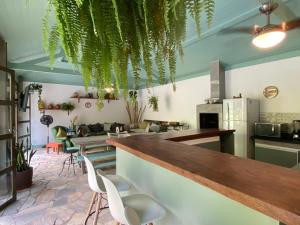 un ristorante con bar con piante appese al soffitto di Vila Maria - Linda Casa de Campo a Rio de Janeiro