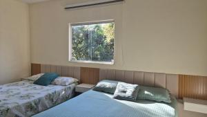 Un dormitorio con dos camas y una ventana. en Recanto do sossego, en Nova Lima 109 fotos más