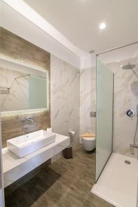 a bathroom with a sink and a toilet at Elektra Hotel in Paleros +81 photos