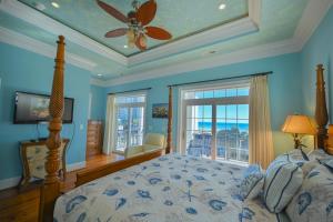 a bedroom with a bed with a ceiling fan and a window at 3BR Luxury Vacation Home - Unbeatable Location and View in Myrtle Beach