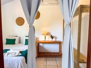a room with a bed and a table with a lamp at Pousada João Maria in Trancoso