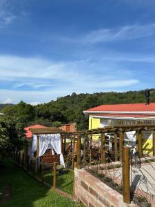 ein Holzzaun mit einem Tisch und einem Gebäude in der Unterkunft Chales Gramado Exclusive in Gramado