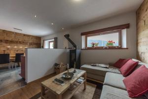 uma sala de estar com um sofá e uma mesa em Monte Campell Dasura em Poschiavo