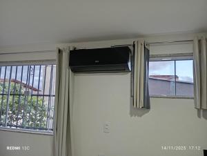 ein Zimmer mit zwei Fenstern und Klimaanlage in der Unterkunft aeroporto e praia loft aconchegante in Vitória