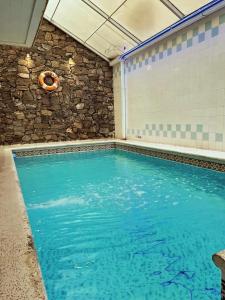 ein Hallenbad mit Steinmauer und blauem Wasser in der Unterkunft Lourdes in Villa Carlos Paz
