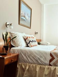 ein Schlafzimmer mit einem Bett, einem Tisch und einem Bild in der Unterkunft Lourdes in Villa Carlos Paz