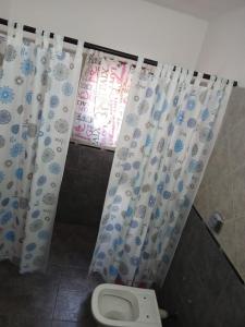 ein Badezimmer mit Toilette und Duschvorhang in der Unterkunft santa rita 2 in Cordoba