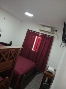 ein Zimmer mit einem roten Vorhang und einem roten Sofa in der Unterkunft santa rita 2 in Cordoba