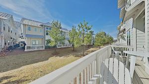 a balcony with a white fence and houses at Prominence 30A - Mint Julep in Inlet Beach