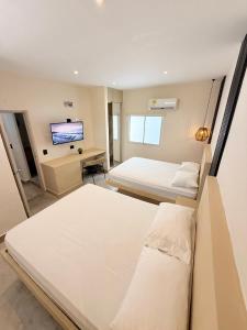 The Host at Santa Marta في سانتا مارتا: غرفة فندقية بسريرين وتلفزيون