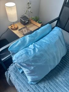 a bed with a blue pillow and a table with a lamp at Luxe Home Near DTLA & Dodgers with Rooftop in Los Angeles