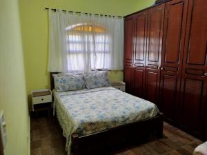 a small bedroom with a bed and a window at Chácara Condomínio Cristal Azul Mairinque in Mairinque
