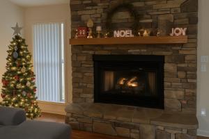 een woonkamer met een kerstboom en een open haard bij Peaceful Mtn View- Hot Tub- Fire Pit- Pets- Pond in Sevierville