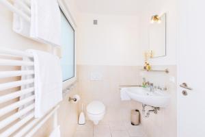 Un baño blanco con inodoro y lavabo. en Pension Altes Backhaus, en Herzogenaurach 18 fotos más