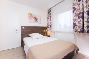 un dormitorio con una cama y una ventana en Pension Altes Backhaus, en Herzogenaurach