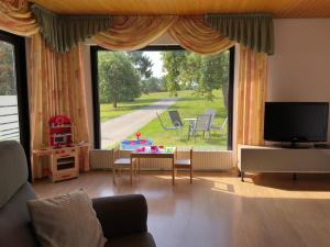 a living room with a large window and a tv at Familiennest-Eifel in Blankenheim +23 photos