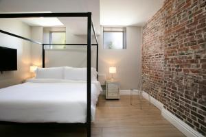 ein Schlafzimmer mit einem Bett und einer Ziegelwand in der Unterkunft The Celestial House by StayLage in Soulard