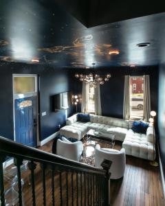 ein Wohnzimmer mit blauen Wänden, einem Sofa und Stühlen in der Unterkunft The Celestial House by StayLage in Soulard