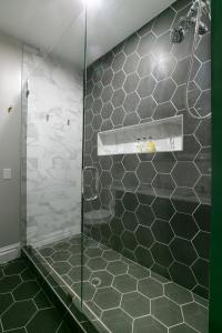 ein Bad mit einer Dusche mit grünen und weißen Fliesen in der Unterkunft The Celestial House by StayLage in Soulard + 20 Fotos