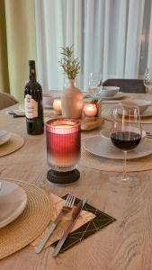 a wooden table with a bottle of wine and a glass at Amadeus Loft in Wilhelmshaven