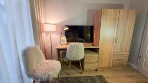 an office with a desk with a laptop and two chairs at Amadeus Loft in Wilhelmshaven