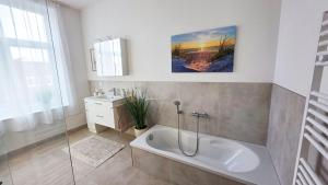 a bathroom with a bath tub and a sink at Amadeus Loft in Wilhelmshaven +23 photos
