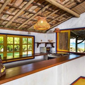 uma cozinha com um balcão e algumas janelas em Casa Mar em Porto Seguro