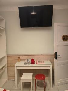 a room with a desk with a television on the wall at Gîte Horizons Landais Séjour professionnel et vacances dans les Landes in Pontonx-sur-lʼAdour