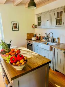 a kitchen with a bowl of fruit on a counter at Wooden Cottage Near The Baltic Sea in Lensahn